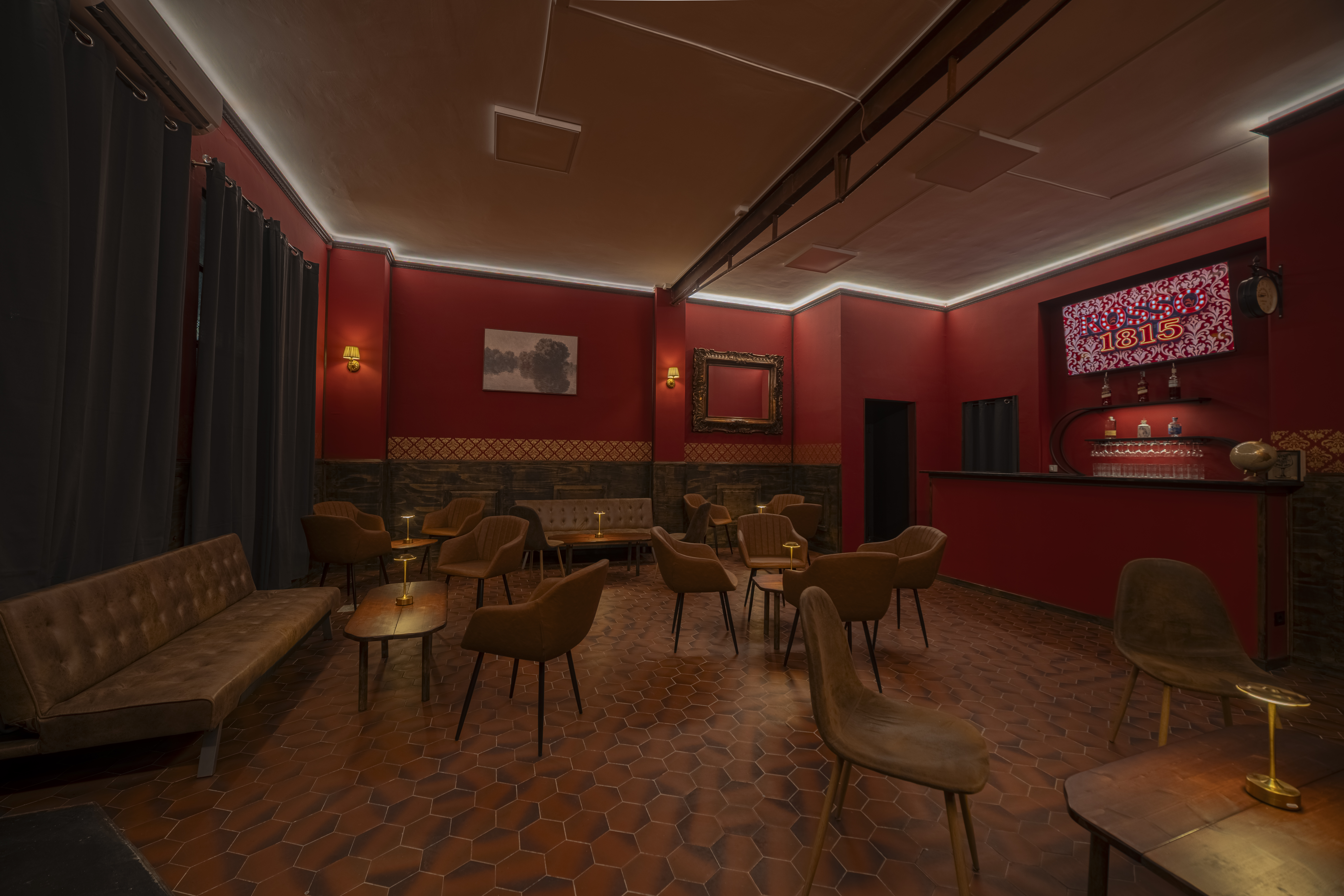 La sala del ROSSO1815 con il bancone sul fondo e le sedute in primo piano